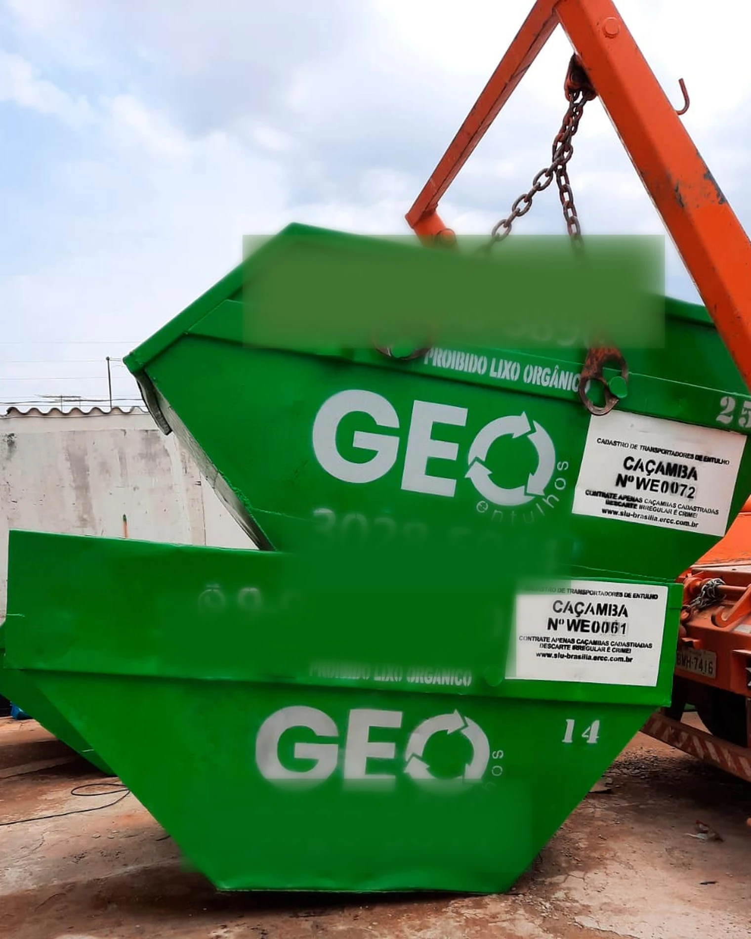Caçambas verdes de um parceiro local sendo movimentadas por caminhão