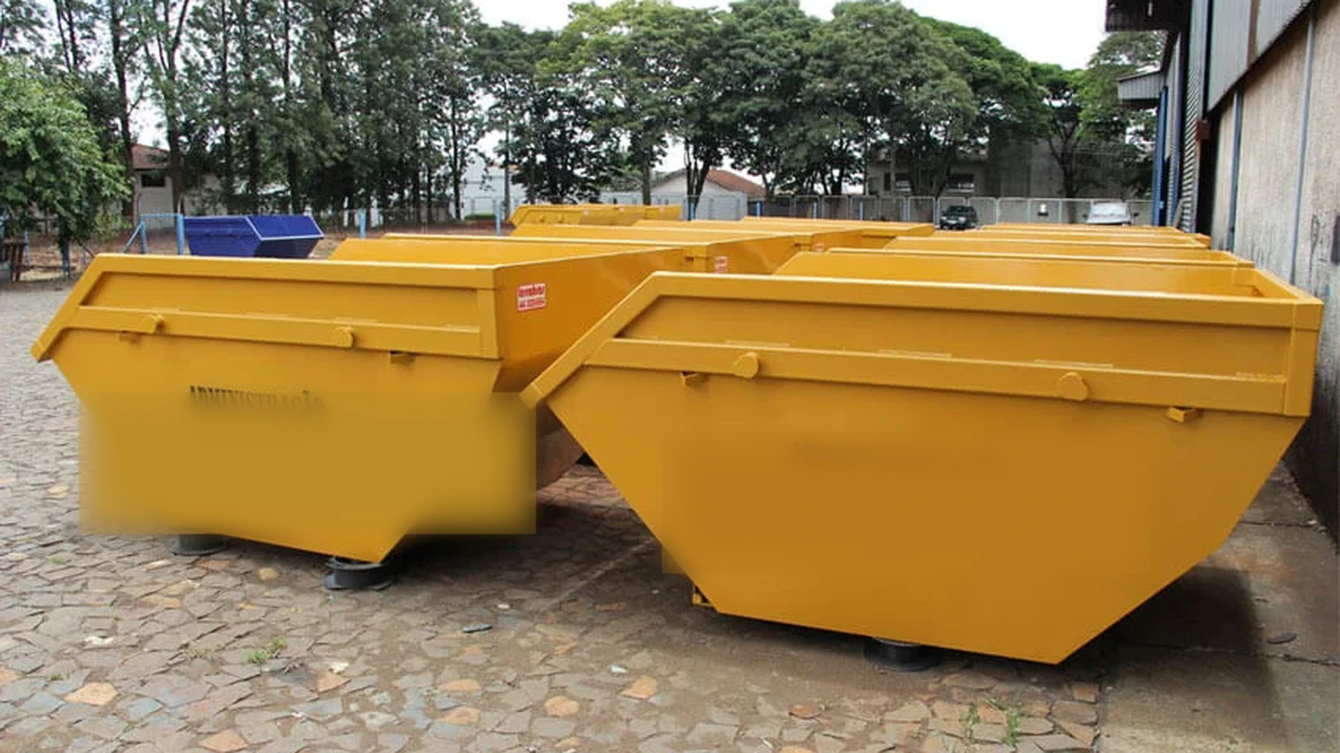 Pátio com várias caçambas amarelas de operação parceira